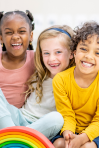 Smiling children enjoying life, learning, growing, and developing with the support of loving caregivers, not punishment.