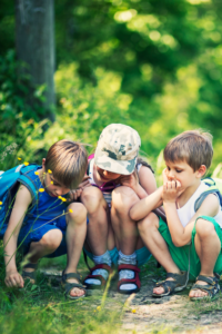 Curious children outside in nature exploring, leaving space for them to learn and grow and develop during their critical window of development